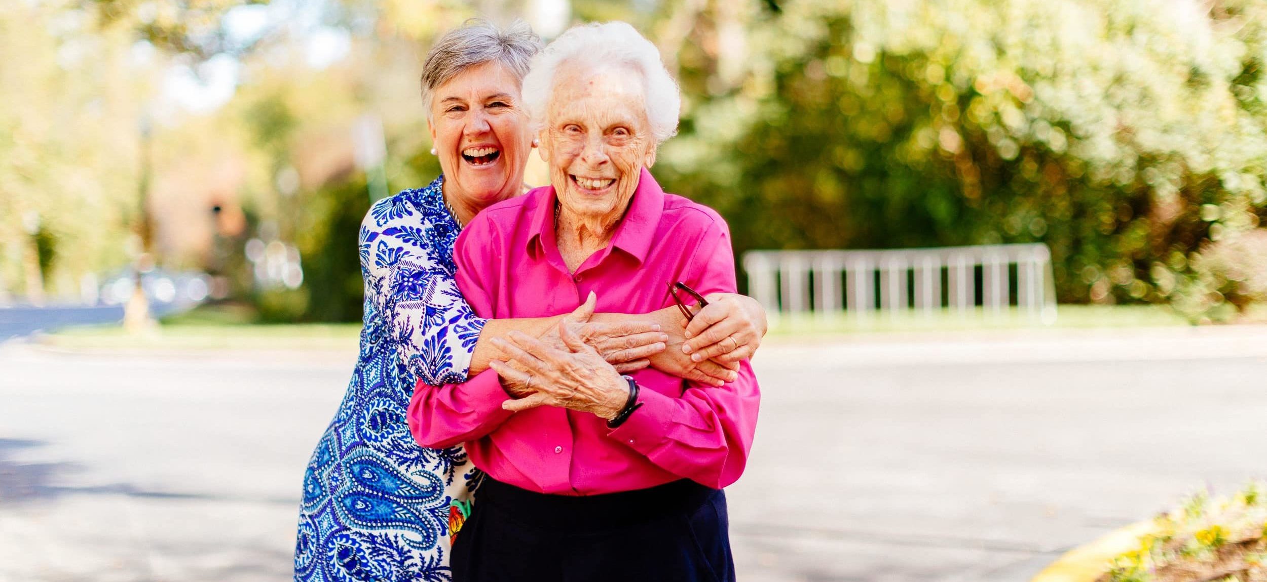 Barb and Independent Living resident at Kensington Park Senior Living enjoy a hug and sunshine