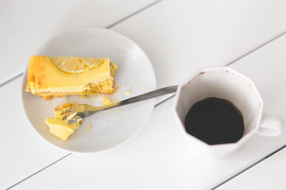 lemon cheesecake and coffee on white table