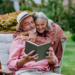 Older couple reading a book outdoors