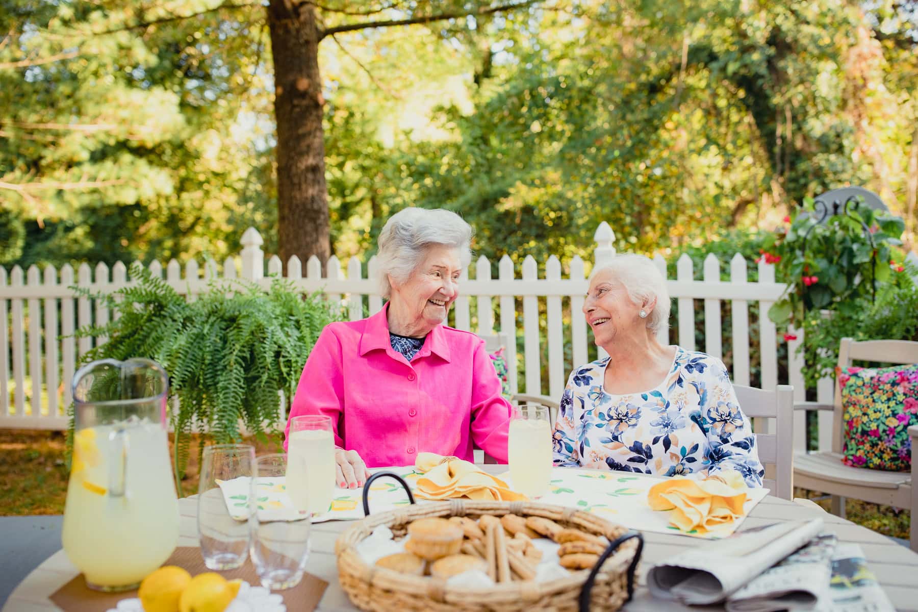 two elderly women sitting on a patio
