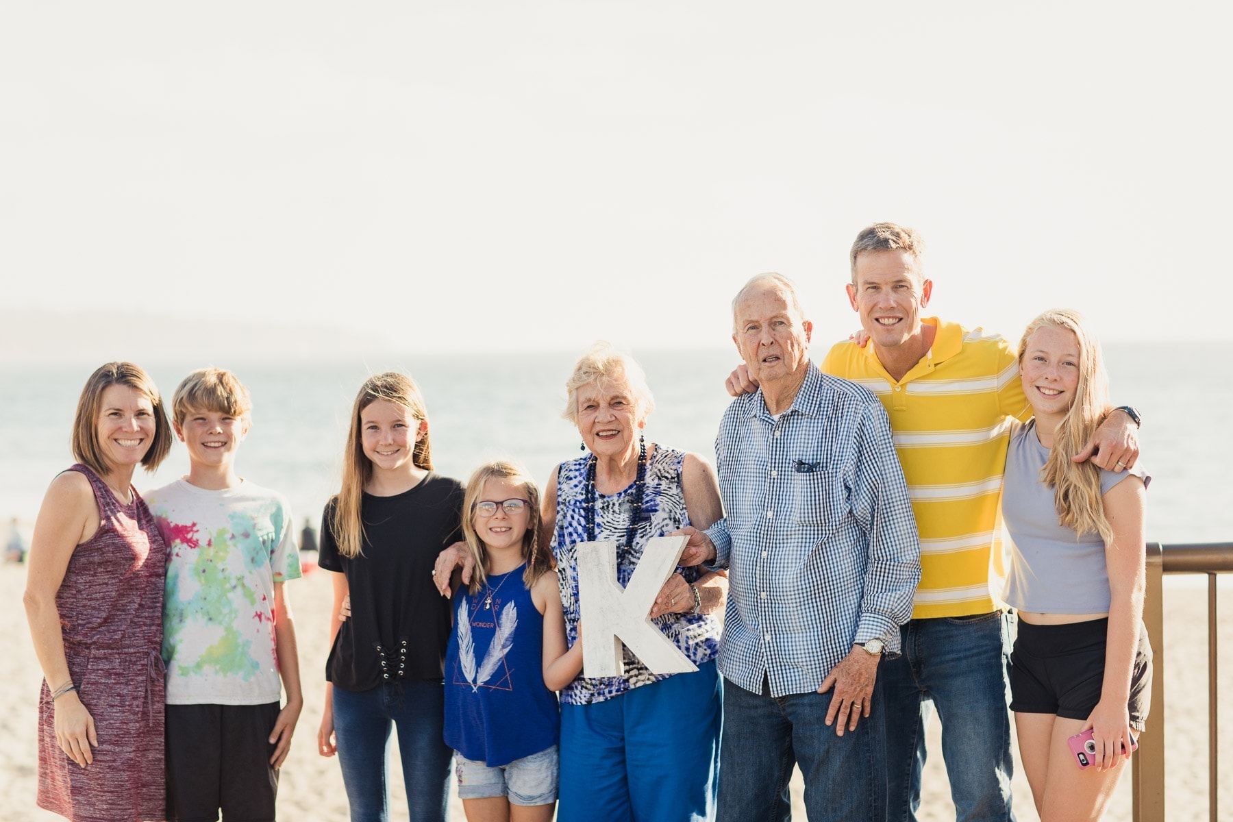 family on the beach holding a K sign