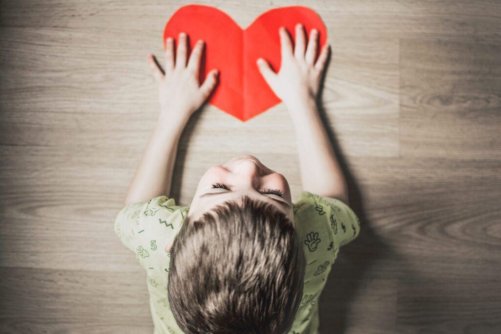 Young boy with red paper heart
