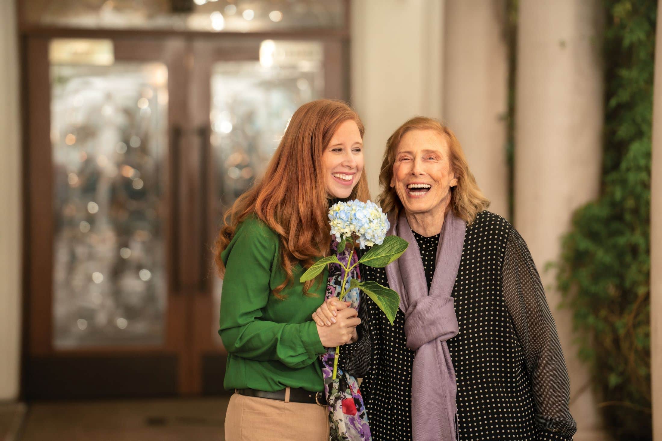 two women holding flowers