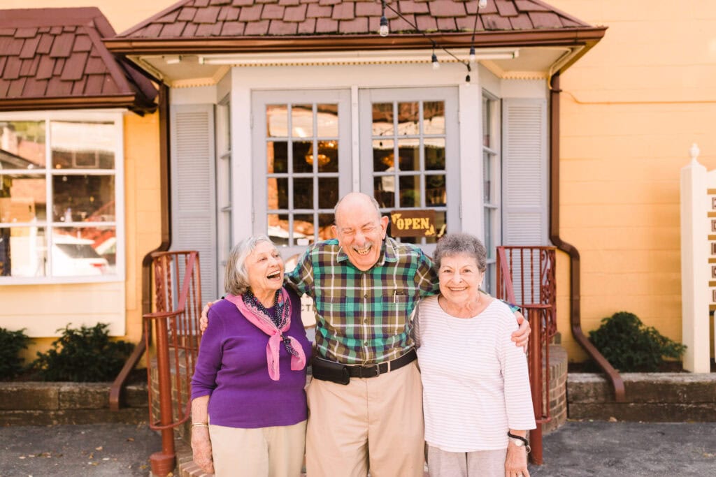 two older women laughing with older man